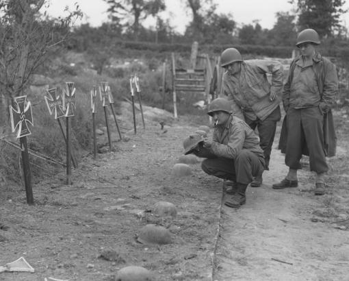 Soldats américains examinant des tombes provisoires allemandes 